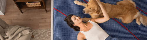 a woman with her golden retreiver relaxing on an Elite mattress model
