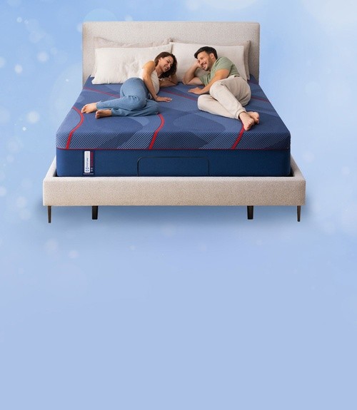 Two people lying on a Sealy Posturepedic mattress