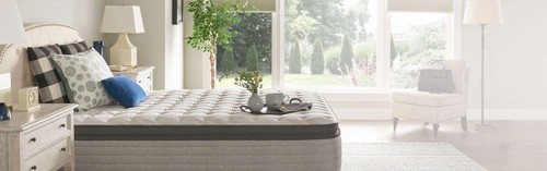 A Posturepedic mattress with a pillow top in a styled room