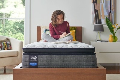 A young woman doing homework on her bed
