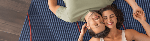 A woman and dog lying on a mattress