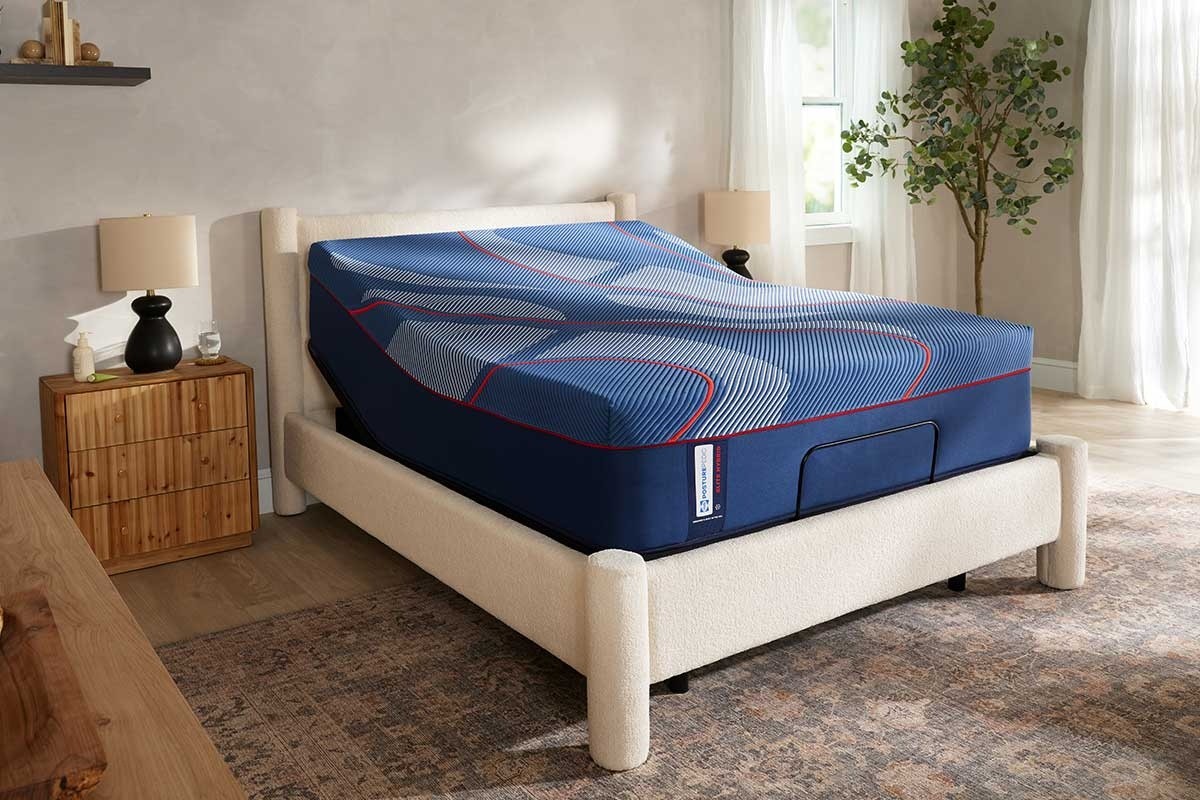 A Posturepedic Elite Hybrid mattress on an adjustable base in a styled room